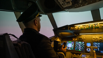 A man is studying to be a pilot in an aircraft simulator. 