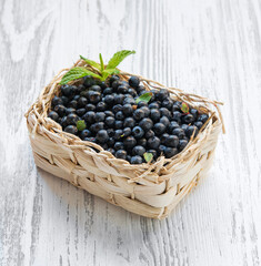 Fresh blueberry in a basket on a white wooden background. Farm healthy and eco-friendly berry and fruit. Rustic style.