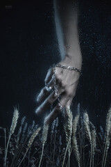 Women's hands with jewelry, photographed through fogged glass with water droplets. Mystical forms. Dark fantasy. Fashion. Body parts. Exquisite fingers.