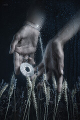 Women's hands with jewelry, photographed through fogged glass with water droplets. Mystical forms. Dark fantasy. Fashion. Body parts. Exquisite fingers.