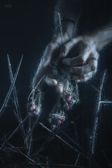Women's hands with jewelry, photographed through fogged glass with water droplets. Mystical forms. Dark fantasy. Fashion. Body parts. Exquisite fingers.