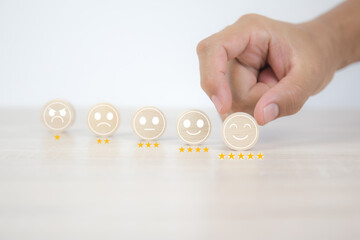 Smile face on wooden toy for customer services rating feedback satisfaction survey business review...