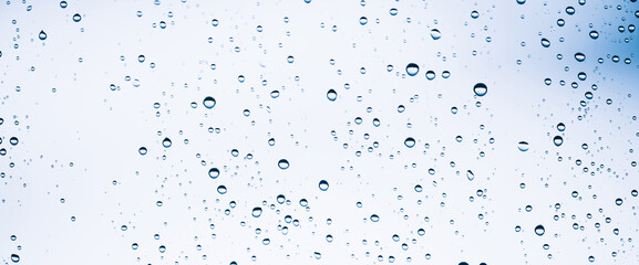 Minimal light backdrop with rain droplets on white glass. Light wet window with rainy drops closeup...