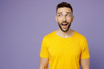 Young surprised shocked astonished impressed amazed caucasian man wear yellow t-shirt look aside on...