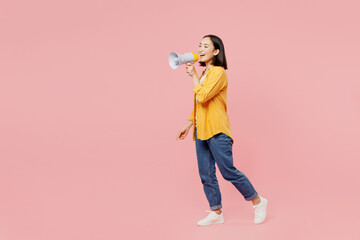 Full body young woman of Asian ethnicity wear yellow shirt white t-shirt hold megaphone scream...