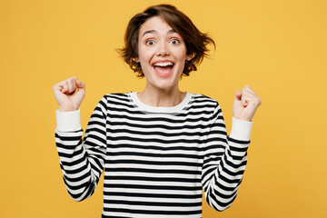 Young exultant overjoyed woman wear casual striped black and white shirt do winner gesture...
