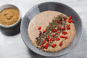 Flaxseed Porridge in a Bowl, Healthy Breakfast or Snack, Porridge Decorated with Chia Seeds and Goji Berries