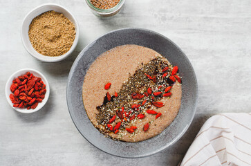 Flaxseed Porridge in a Bowl, Healthy Breakfast or Snack, Porridge Decorated with Chia Seeds and Goji Berries