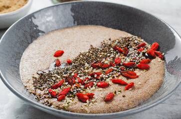 Flaxseed Porridge in a Bowl, Healthy Breakfast or Snack, Porridge Decorated with Chia Seeds and Goji Berries
