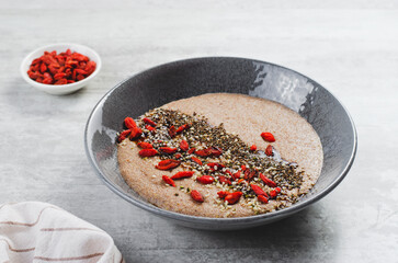 Flaxseed Porridge in a Bowl, Healthy Breakfast or Snack, Porridge Decorated with Chia Seeds and Goji Berries