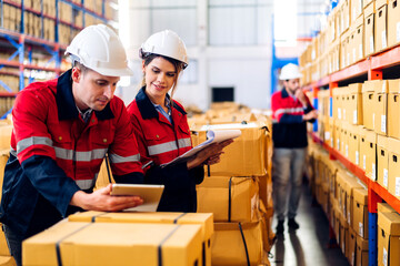 Two engineer team shipping order detail on tablet check goods and supplies on shelves with goods background inventory in factory warehouse.logistic industry and business export