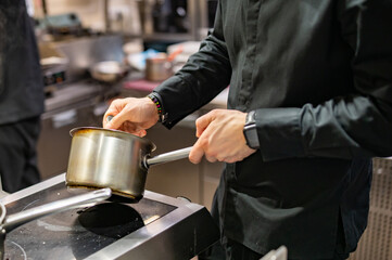 Chef hands cooking sauce in the restaurant kitchen