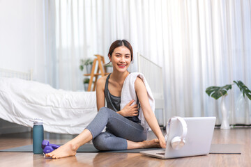 Portrait sport asian beauty body slim woman in sportswear sitting relax and girl practicing yoga and do fitness exercise with laptop computer in bedroom at home.Diet concept.Fitness and healthy