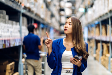 Portrait asian businesswoman shipping order detail check goods and supplies on shelves with goods background inventory in factory warehouse.logistic industry and business import export