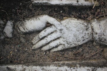 Hands shaking on a  tombstone.