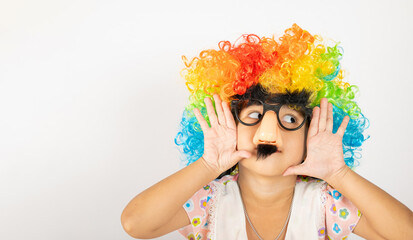 April Fool's Day. Two brothers funny kid little girl clown wears curly wig colorful big nos and...