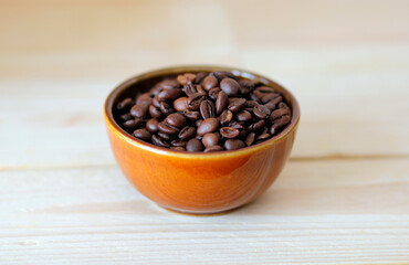 close-up of brown coffee beans in a bowl, coffee beans background, coffee beans in a bowl on wooden table, space for text, roasted coffee beans