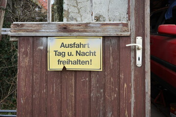 Kaputte braune alte Holztür mit Schild in Gelb vor einem alten Haus in der Provinz in Heiden bei...