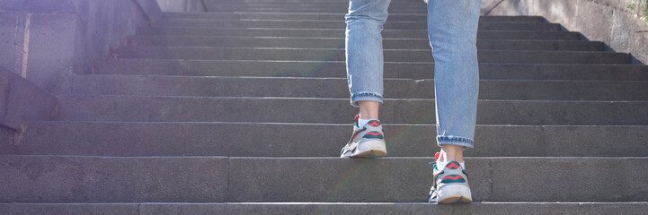 Woman in jeans going up steep stairs