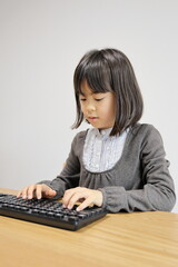 キーボードを打つ女子小学生 (8歳)