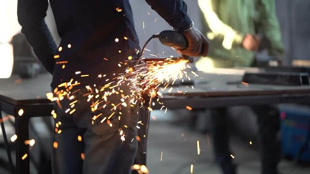 Working with Power Tools - Stock video of Man Using Angle Grinder with Sparks Flying, Man using angle grinder sparks, Worker cutting metal with grinder
