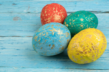 Happy Easter card. Colorful shiny easter eggs on wooden background. Copy space for text.