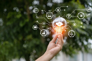 Hand holding light bulb in nature on green background for energy concept.