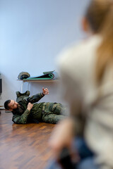  A bearded man in his 40s, a military medic lies on the floor and demonstrates to civilians in the...