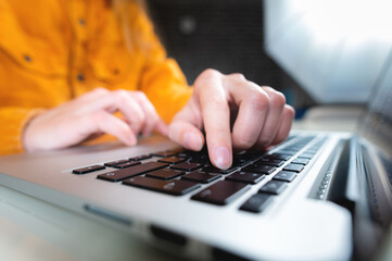 woman using laptop, searching the internet, browsing information, concept of having a workplace at home. close-up of a finger typing on a laptop