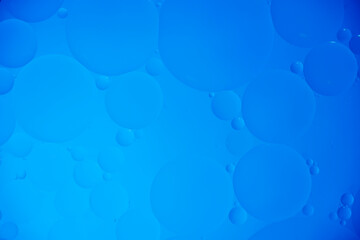 Blue abstract background with oil circles, streaks and gradient.