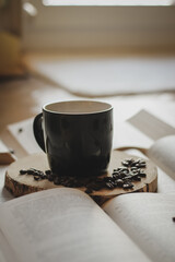 morning coffee, coffee beans and cup on wood and books