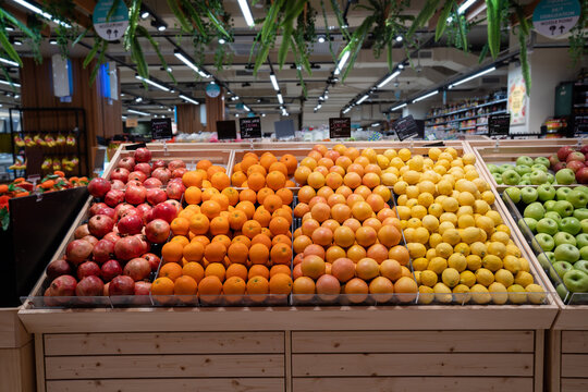 Various type of fresh fruits arrange neatly grocery store. Apple, Orange, Pomegranate, Lemon on rack.