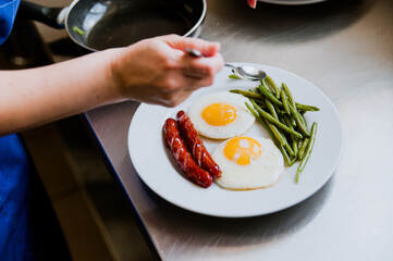 Fried eggs for tomorrow with fried sausages and herbs