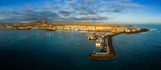 Spectacular mid level panoramic aerial view of the ferry terminal, jetty and harbour early morning in Corralejo in Fuerteventura Spain