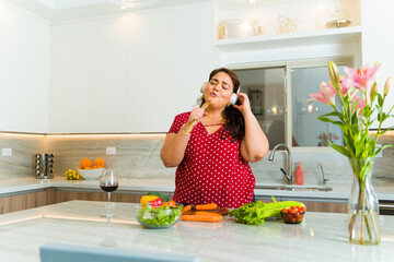 Happy fat woman having fun in a luxury kitchen cooking lunch