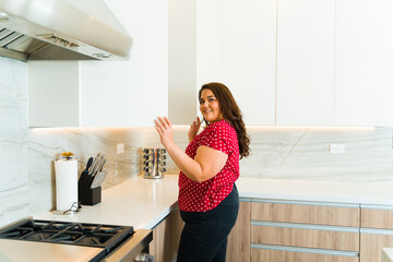 Young woman using the cupboard of the luxury kitchen
