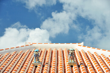 沖縄県小浜島　青空とシーサーと赤瓦の屋根