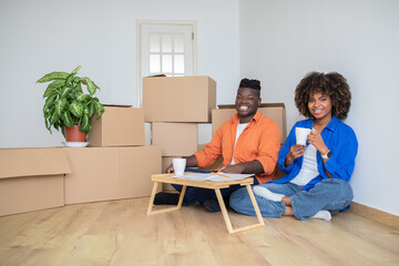 Happy Black Couple Relaxing With Coffee After Moving To New Home