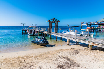 A view of marine vessel beside a jetty in West Bay on Roatan Island on a sunny day