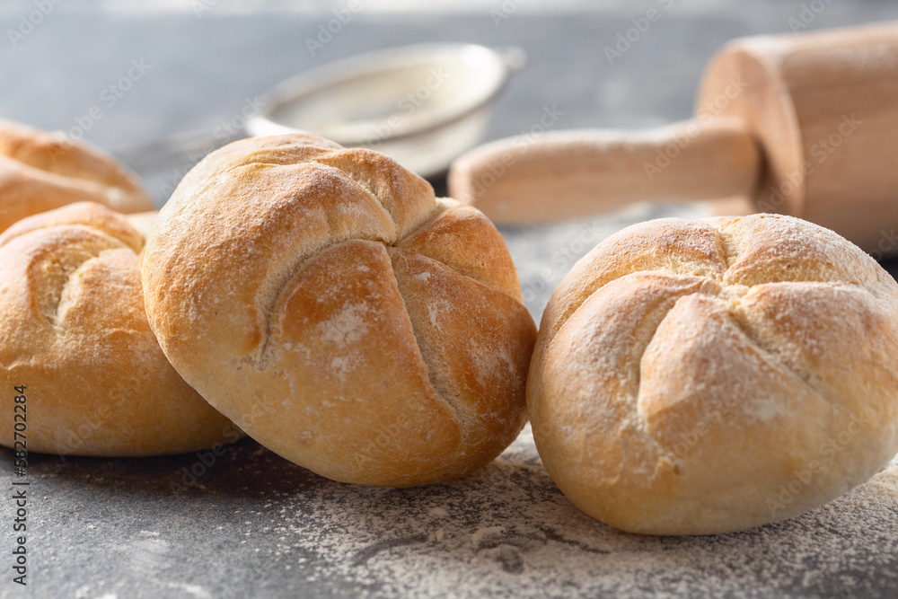 Poster set of small bun bread on the dark table with rolling pin. fresh home baking concept