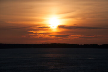 Sunset over a frozen lake and forest in the horizon