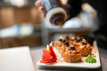 professional chef's hands making sushi and rolls in a restaurant kitchen