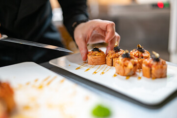 professional chef's hands making sushi and rolls in a restaurant kitchen