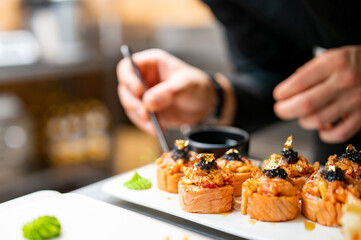 professional chef's hands making sushi and rolls in a restaurant kitchen