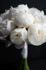 Fototapeta na wymiar White peony wedding bouquet on darck background. White bridal bouquet. Wedding day.