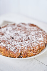 Carrot and raisin pie in a plate on a white table. Gluten-free pie without milk and without eggs. Selective focus, space for text. Dietary dessert. The concept of healthy eating. High quality photo