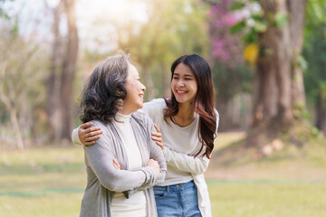 Fototapeta premium Close up of Adult daughter holding her elderly mother hand with love and walk together
