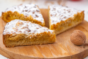 apple and nuts pie on wooden desk on white table