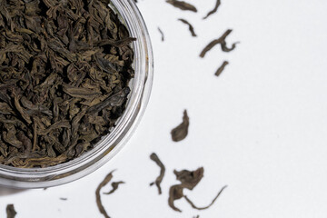 Czarna herbata w słoiku na rozmytym tle z pojedynczych liści 