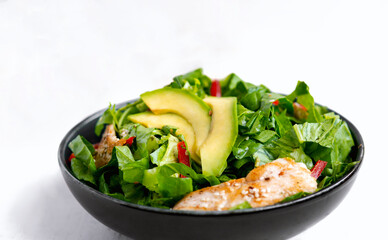 chicken salad with avocado in a black bowl. Healthy food